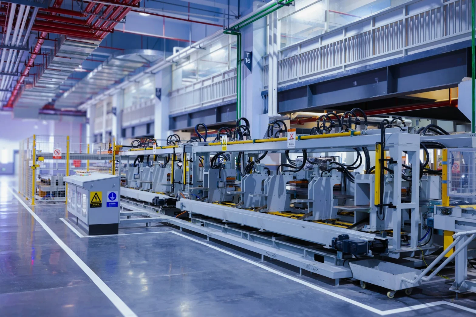 A view of the refrigerator manufacturing plant's fully automated side panel forming line.Translation: "Warning:Danger Prohibit reach into;elecric shock;must connect an earth terminal to the ground"